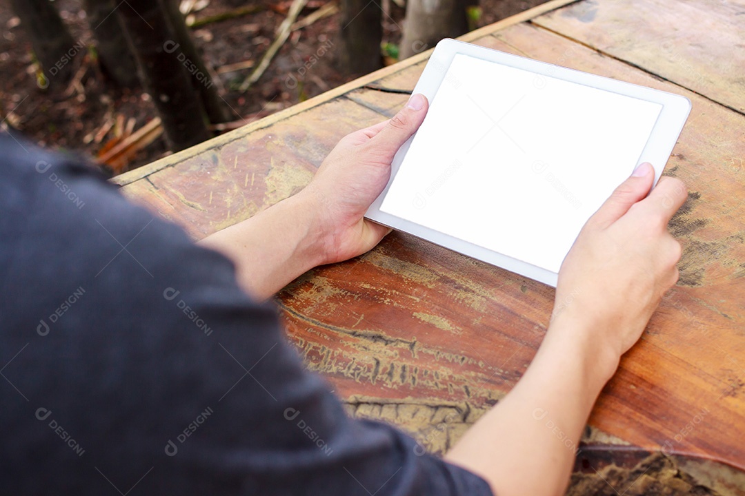 Closeup computador tablet na mão do homem asiático na mesa de madeira texturizada
