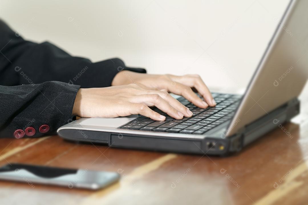 Mãos de empresária no teclado de seu computador portátil. Mulher trabalhando no laptop