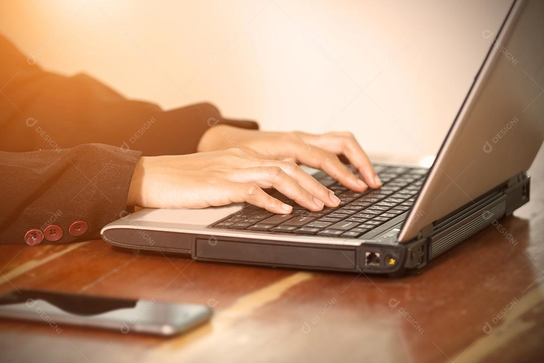 Mãos de empresária no teclado de seu computador portátil. Mulher trabalhando no laptop