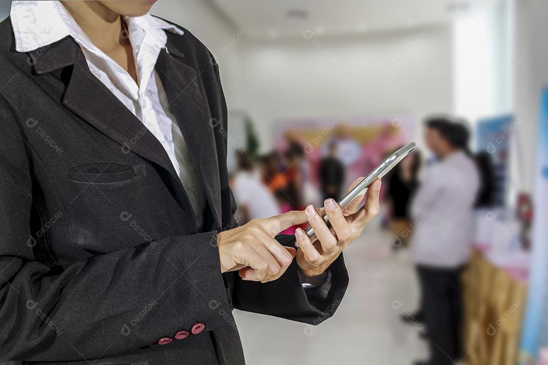 Empresário e mulher estão usando telefone inteligente móvel e sensível ao toque para comunicação