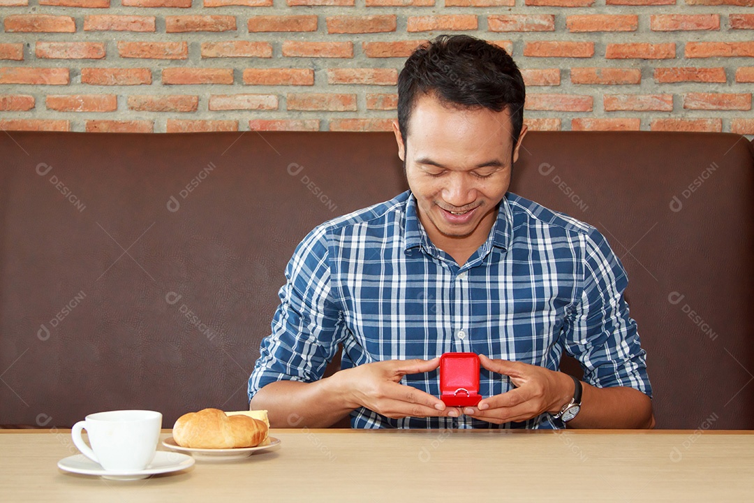 Homem segurando caixa com anel fazendo pedido de casamento para sua namorada
