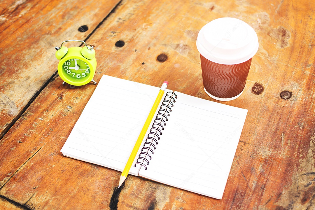 Caderno aberto e xícara de café e relógio em fundo de madeira