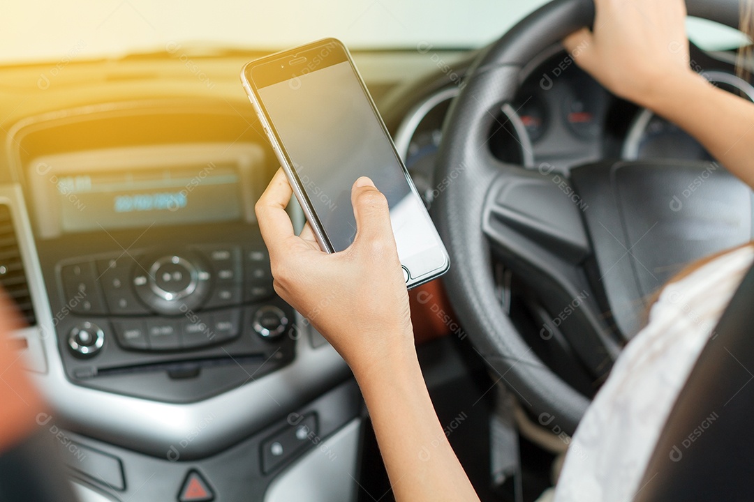 Mulher asiática estão dirigindo carros e usando um smartphone na estrada.