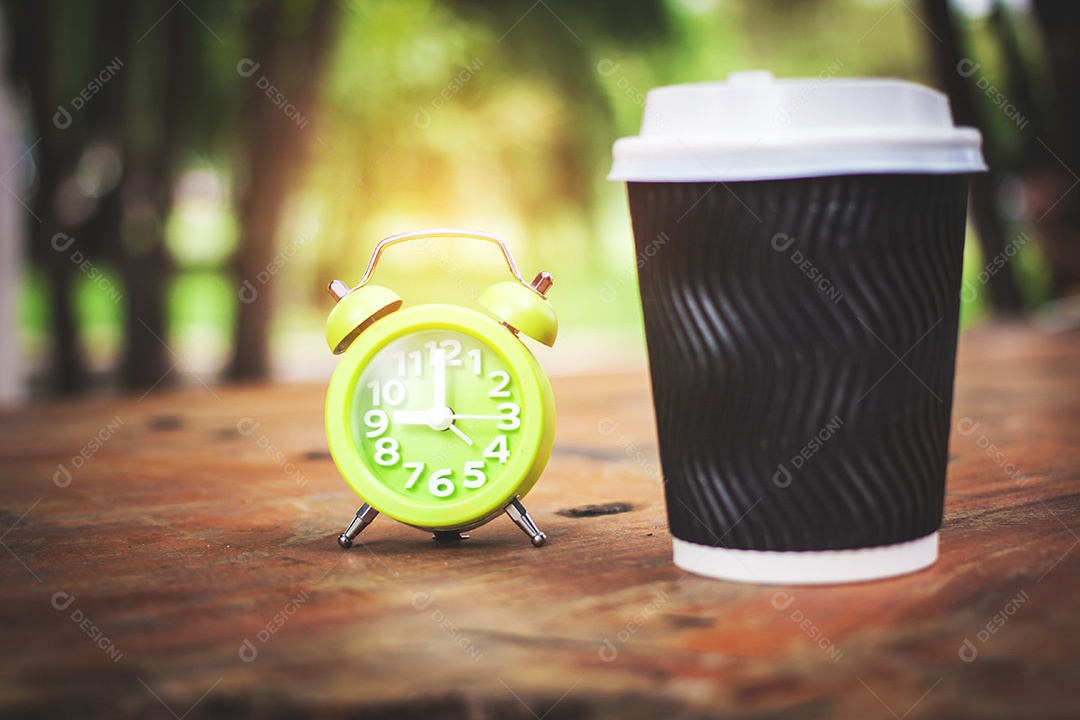 Xícara de café com despertador em cima da mesa