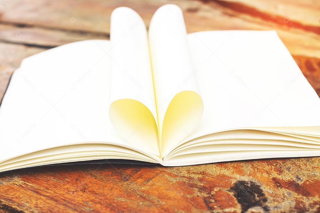 Livro aberto com páginas em forma de coração na mesa de madeira