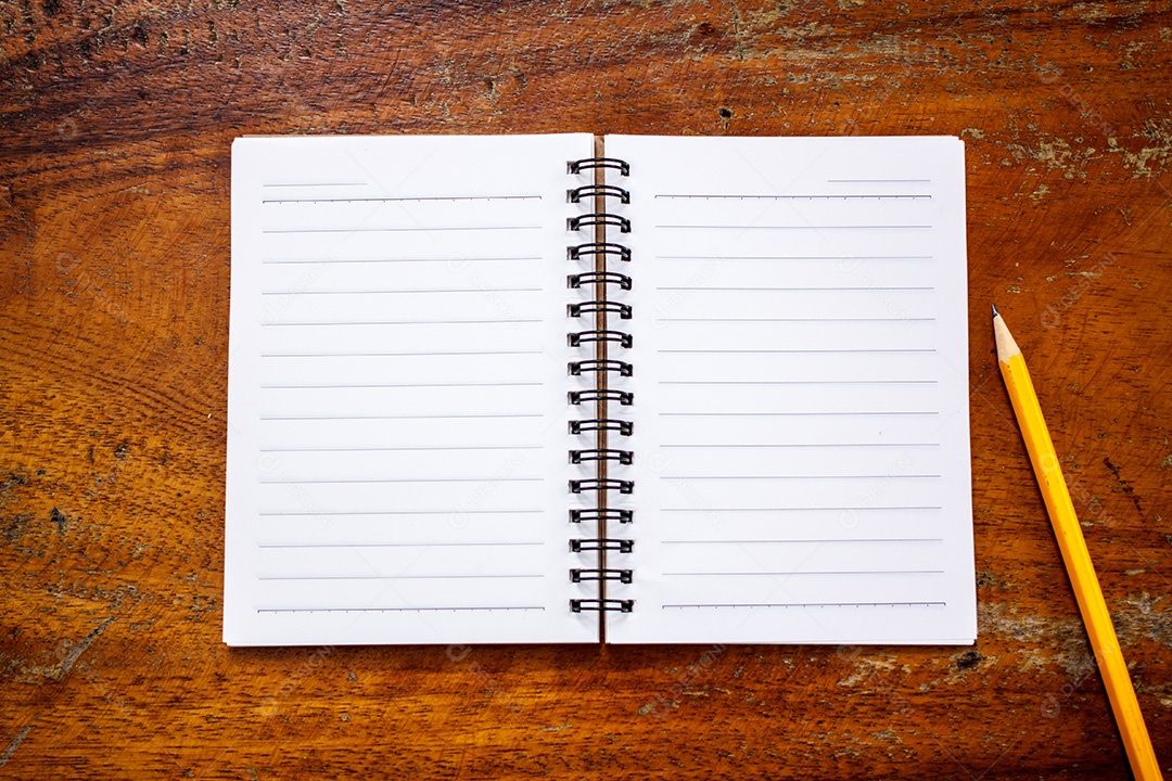 Livro de trabalho com lápis na mesa de madeira
