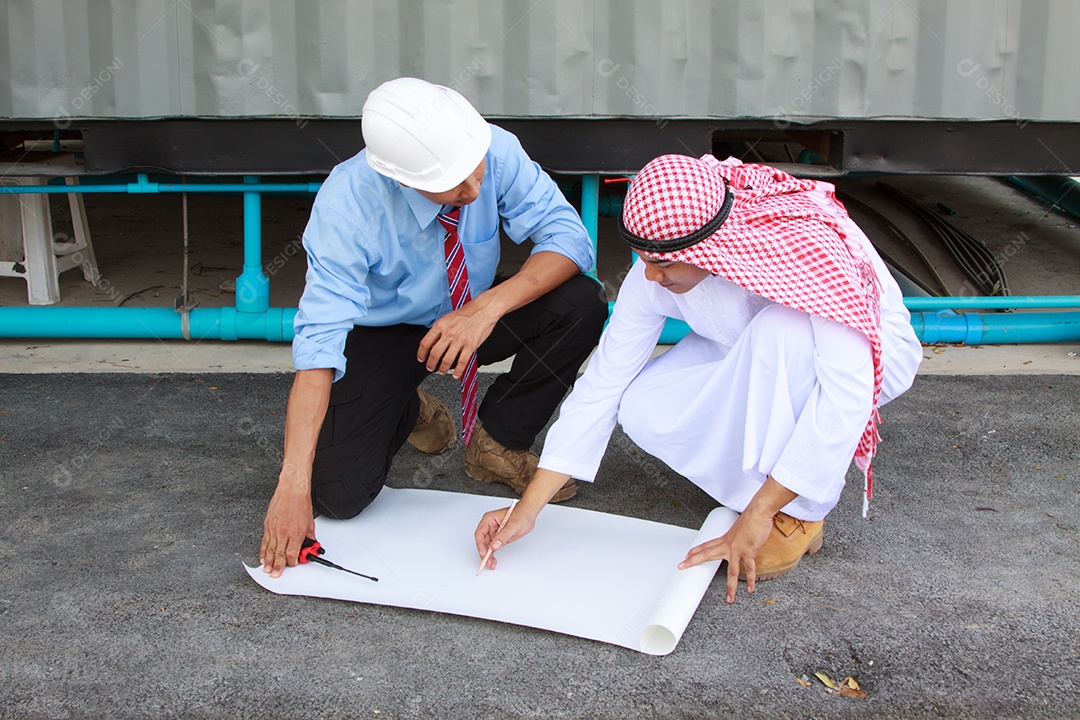 Foto do jovem engenheiro com plantas mostrando algo para ele
