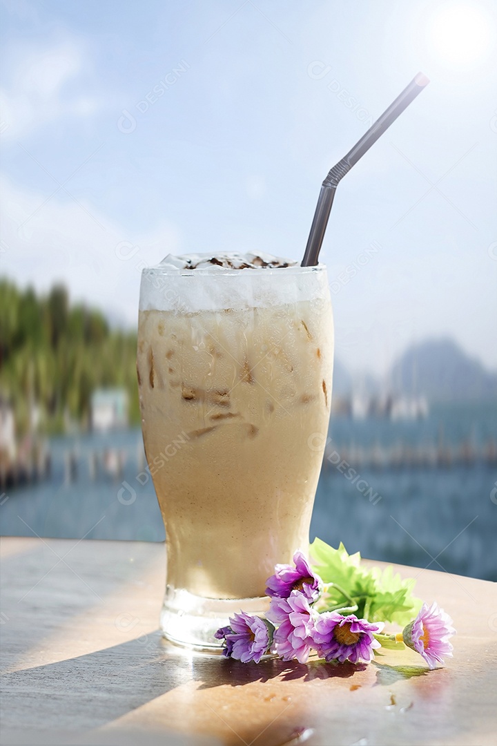 Iced cappuccino coffee on a wooden table in the background of the sea view
