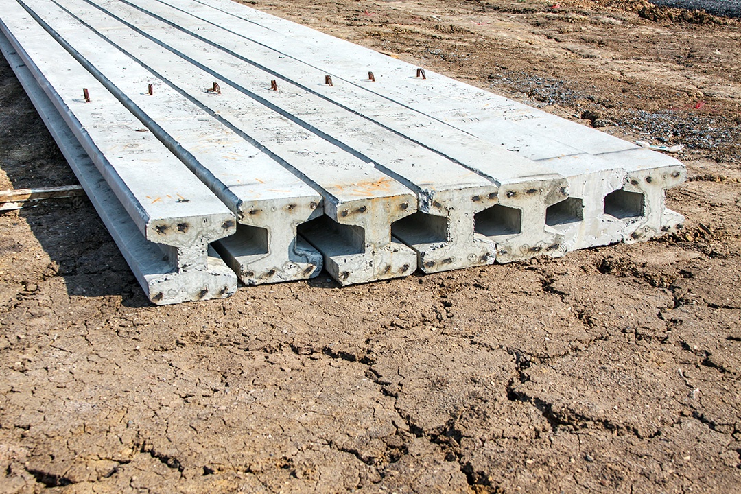 Estaca concreta no canteiro de obras com caminhão amarelo no fundo