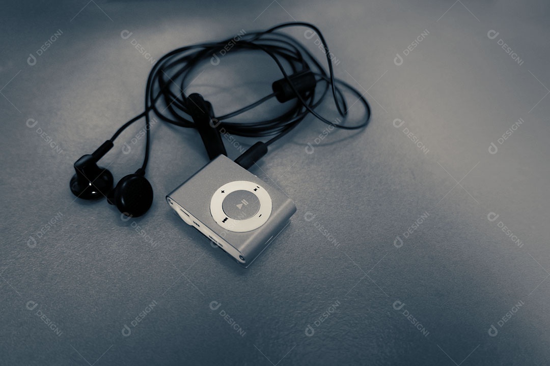 Mp3 player com fone de ouvido Small Talk na mesa de madeira em tom escuro