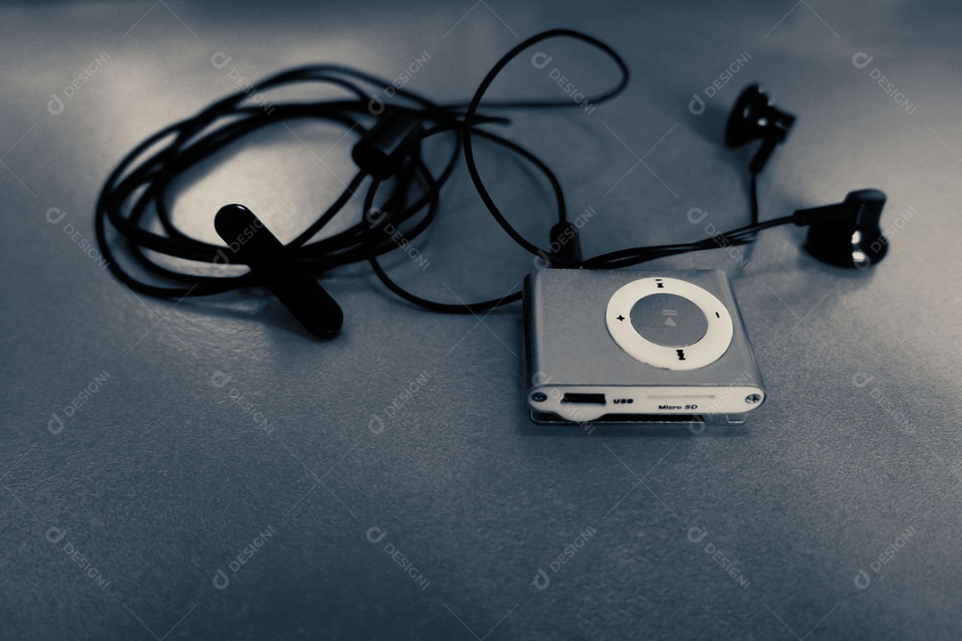 Mp3 player com fone de ouvido Small Talk na mesa de madeira em tom escuro