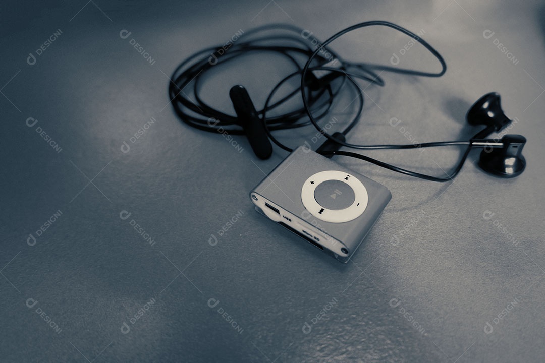 Mp3 player com fone de ouvido Small Talk na mesa de madeira em tom escuro