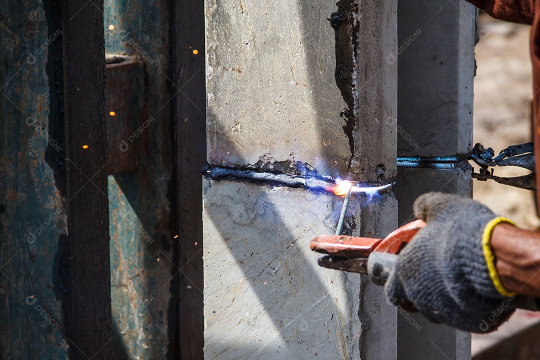 Mão de trabalhador soldador segurando a tocha de soldagem a arco trabalhando em metal