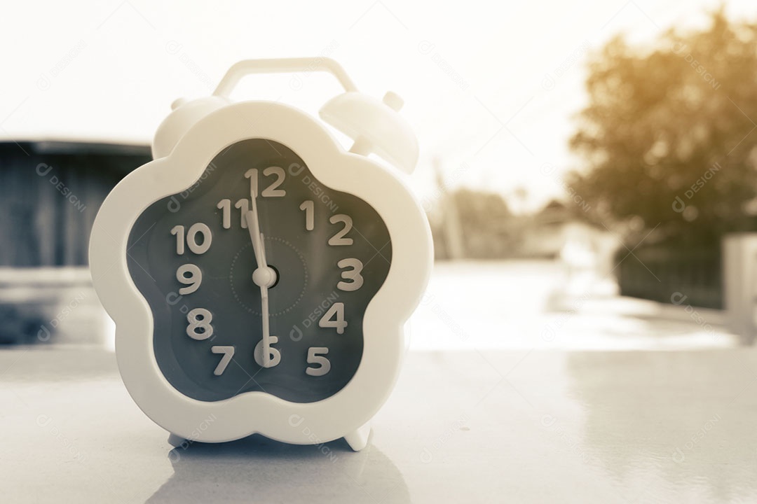 Relógio despertador com atmosfera matinal de campo