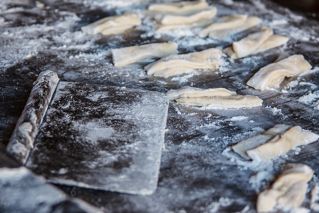 Corte a massa em uma mesa com farinha