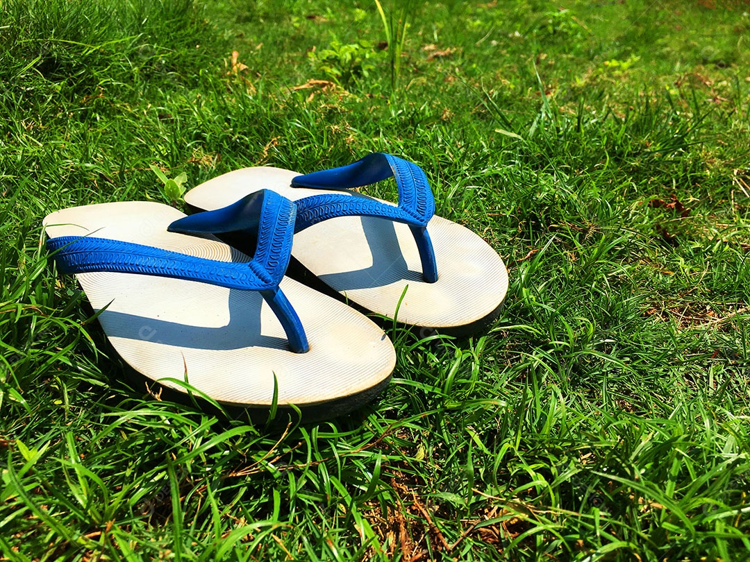 Chinelo de dedo sobre gramado