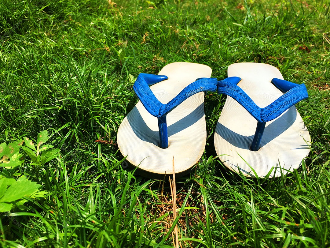 Chinelo de dedo sobre gramado