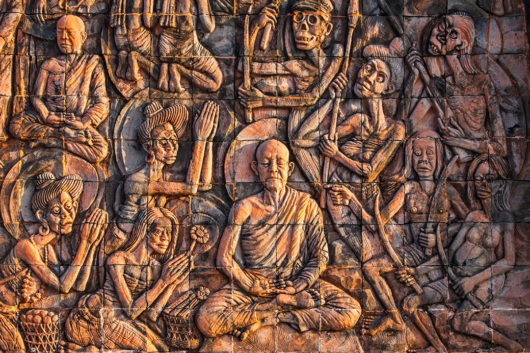Arte na pedra sobre a história de Buda na parede do templo na Tailândia