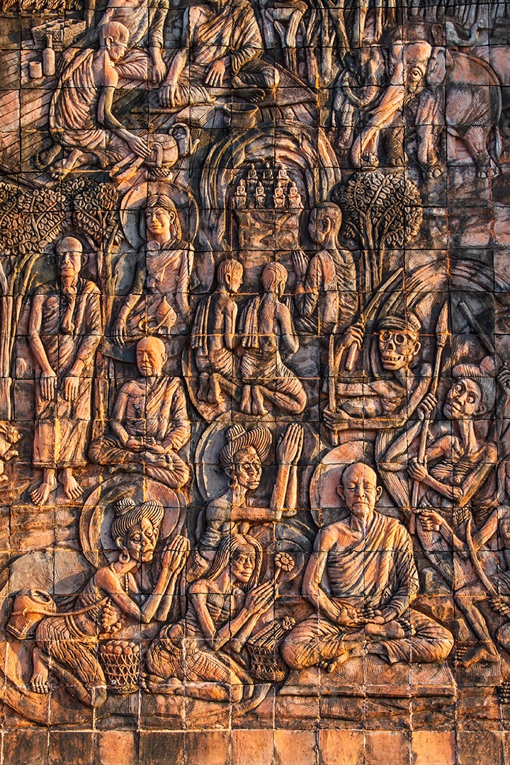 Arte na pedra sobre a história de buda na parede do templo Tailândia