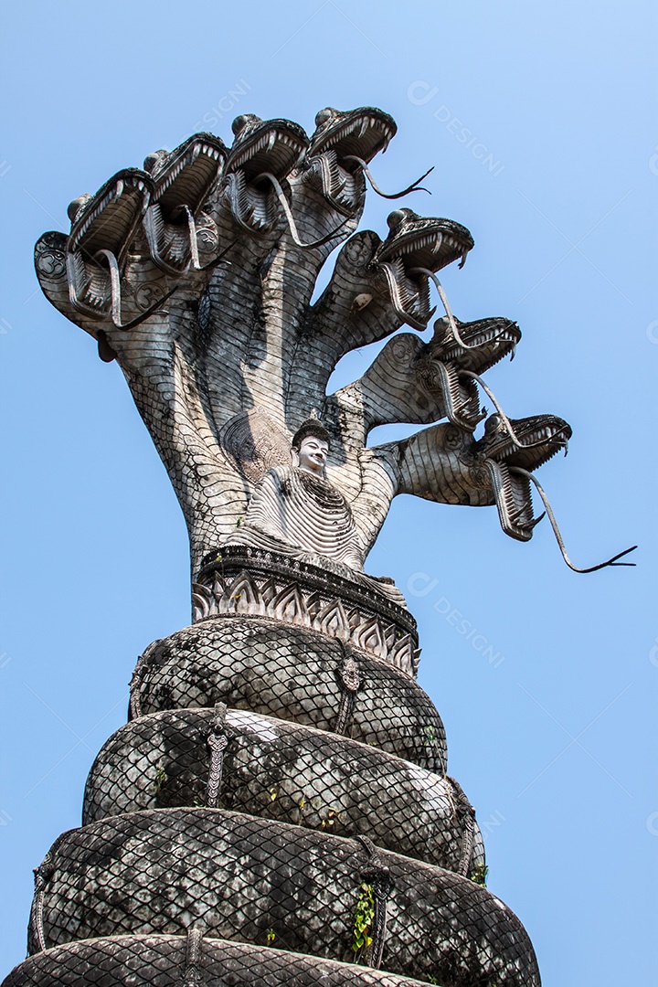 Grande imagem de Buda sentado sob o dossel de cabeças de serpente