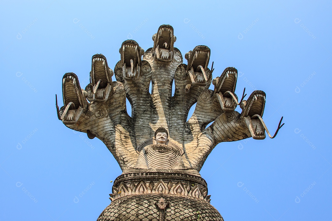 Grande imagem de Buda sentado sob o dossel de cabeças de serpente