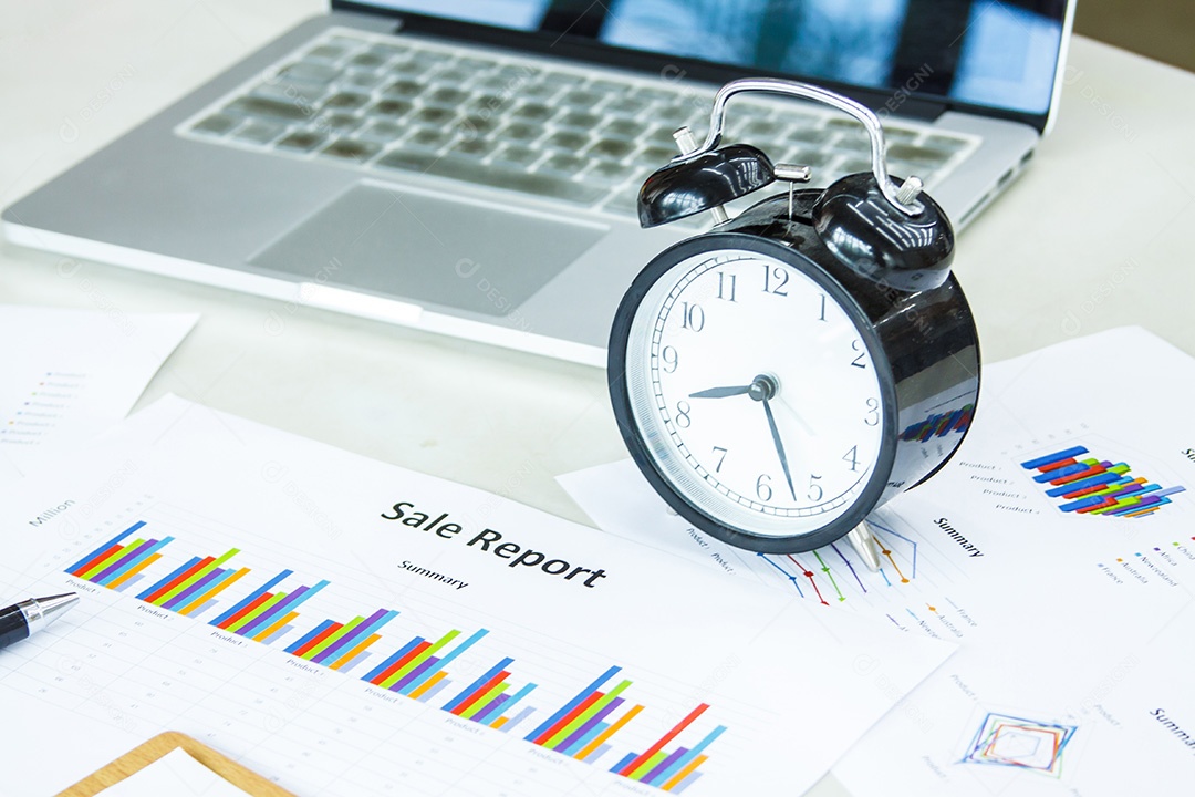 Relógio despertador, notebook, gráfico em sua mesa