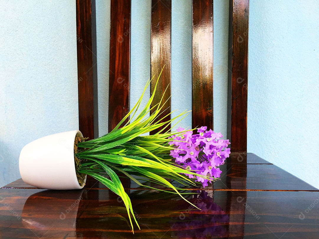 Vaso de flor caído sobre cadeira de madeira