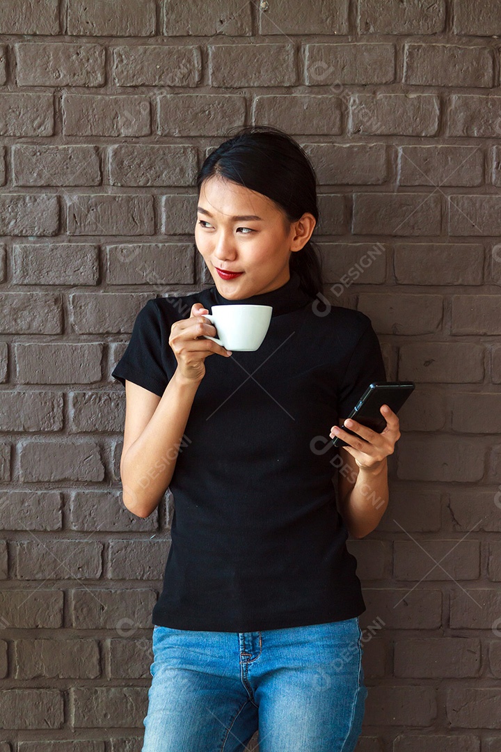 Mulheres bonitas asiáticas sorrindo com uma xícara de café.
