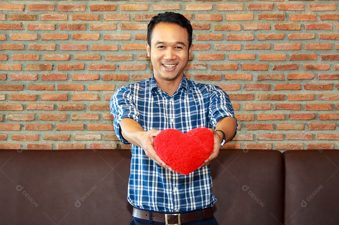 Homem segurando coração vermelho nas mãos