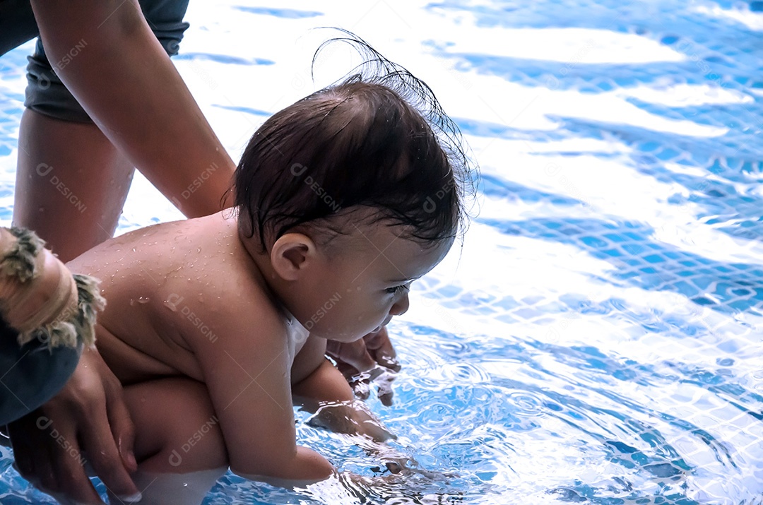 Bebê infantil feliz desfrutando de seu primeiro mergulho na piscina