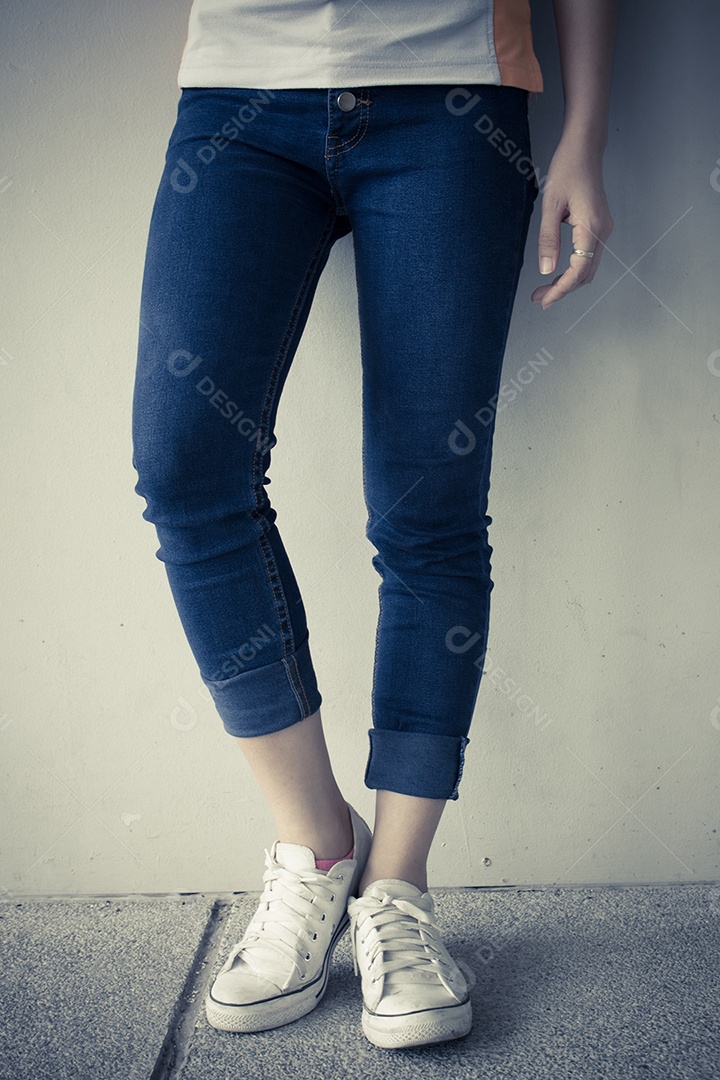 Detalhe da mulher vestindo jeans, fundo de tom vintage