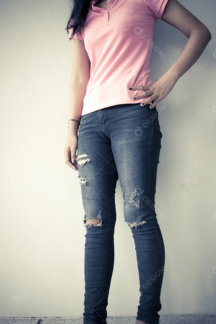 Pernas de moda jovem em jeans, fundo de tom vintage