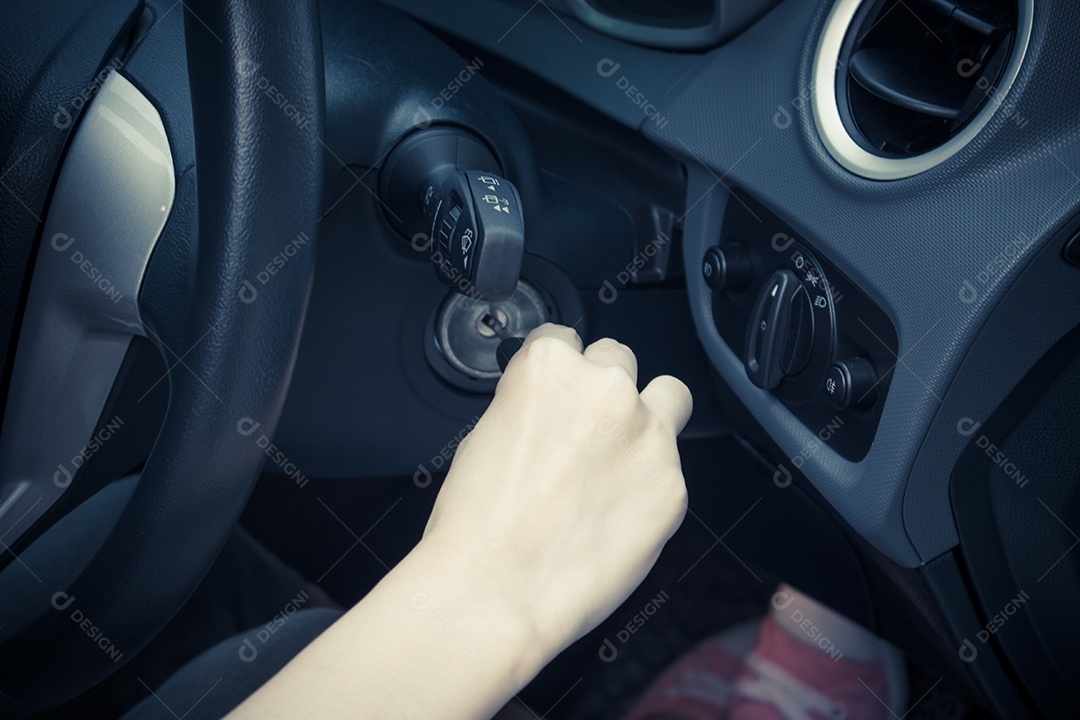 Close de uma mulher ligando o carro.