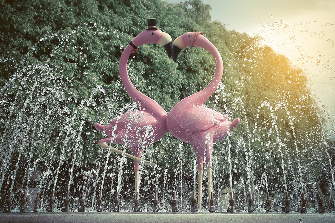 Fonte com um par de lindos flamingos fundo de céu azul com