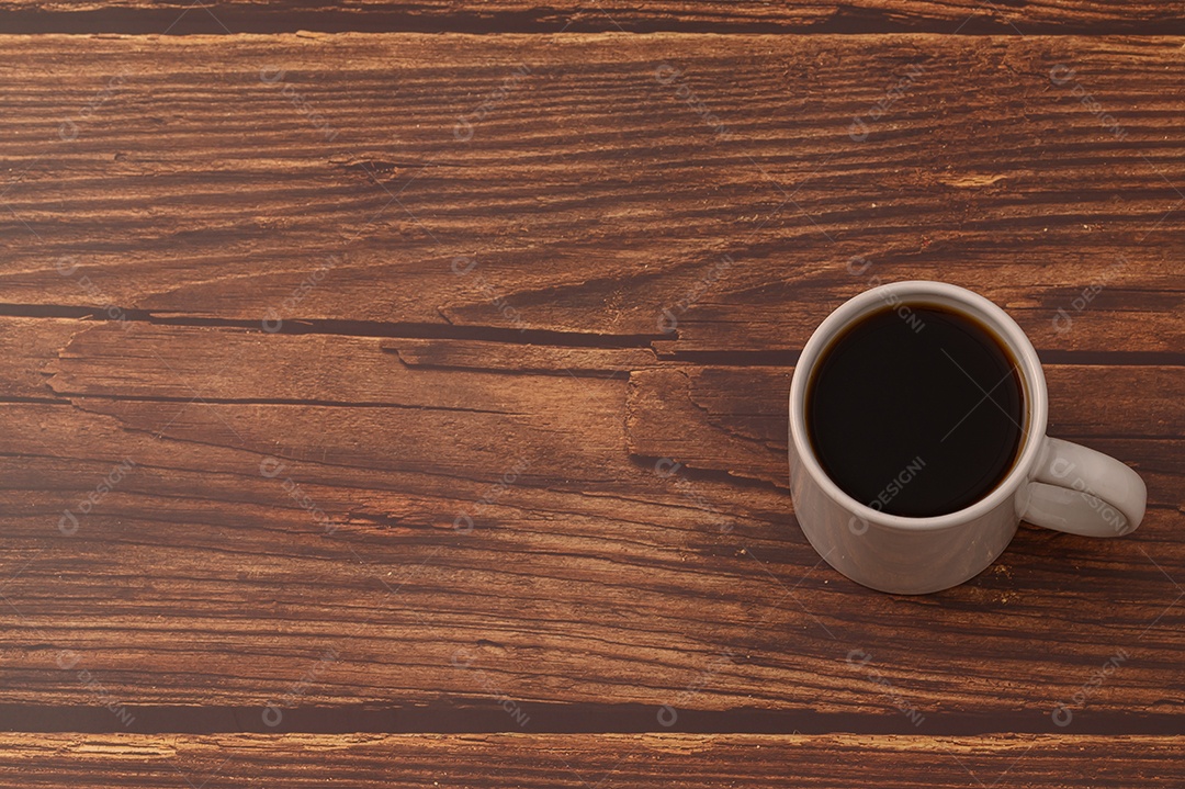 Caneca de café está na mesa.