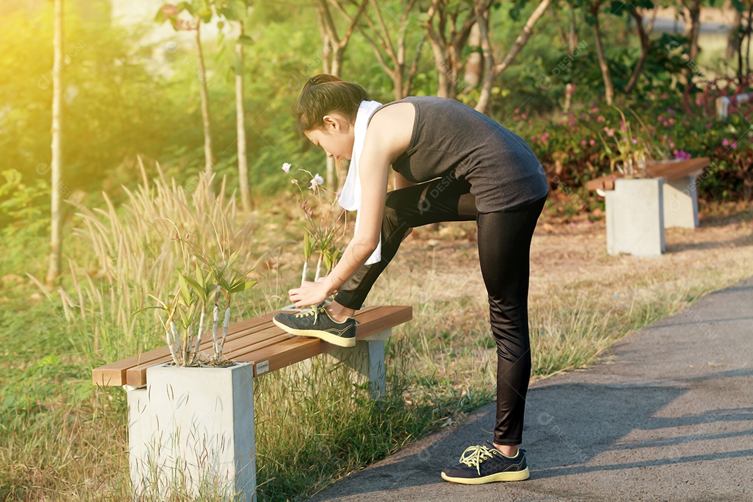 Mulher atlética ásia aquecendo e jovem atleta sentada em um exercício e alongamento em um parque antes do corredor