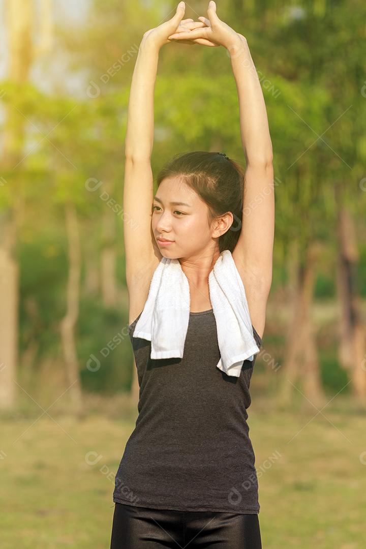 Mulher atlética ásia aquecendo e jovem atleta sentada em um exercício e alongamento em um parque antes do corredor