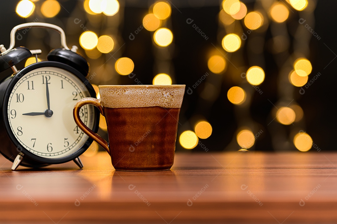 Caneca de café está sobre a mesa. Cenário de luzes de bokeh laranja