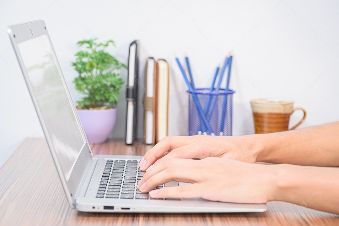 Mão usando um laptop Na mesa da sala