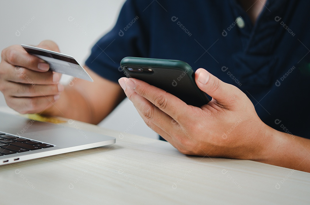 mão de homem segurando cartão de crédito e telefone celular compras on-line e-commerce e internet banking.