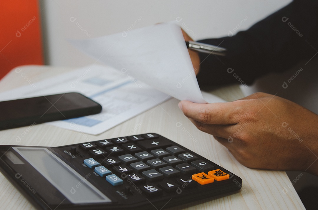 Homem de negócios usando calculadora em uma mesa. Conceitos de finanças, impostos e investimentos empresariais.