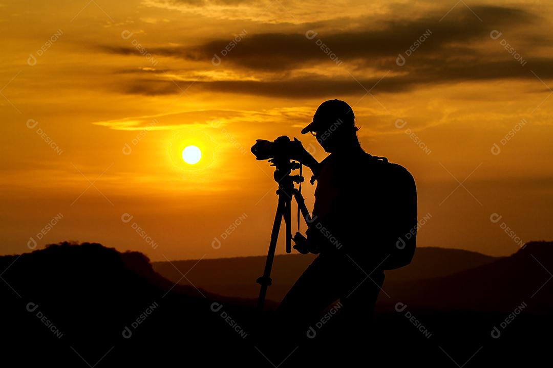 silhueta de fotografia de mulher asiáticas tire uma foto com montanha ao pôr do sol, foco suave
