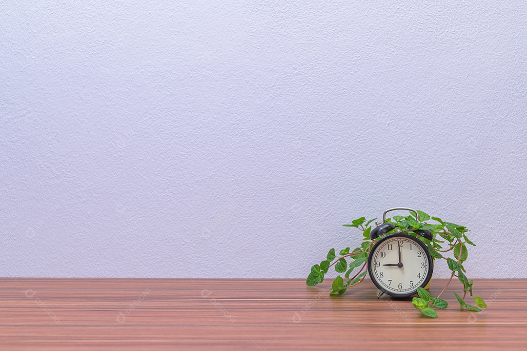 Relógio e a árvore estão na mesa