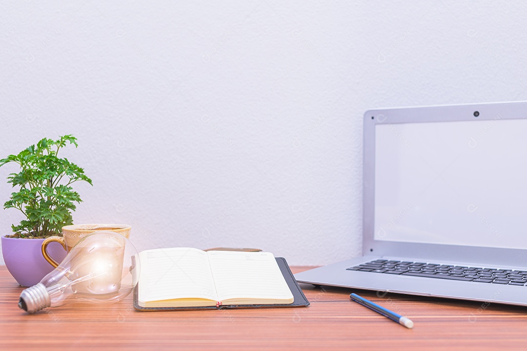 Computador, notebook e livros, documentos e artigos de papelaria em sua mesa