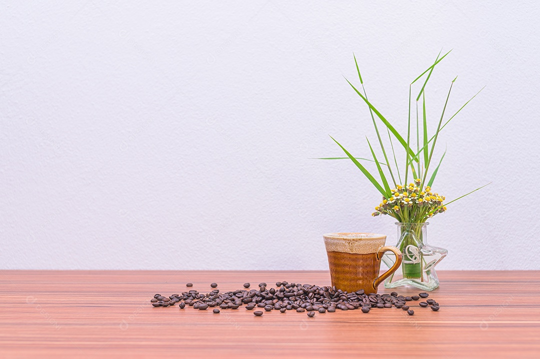 Grãos de café e vasos de flores na mesa