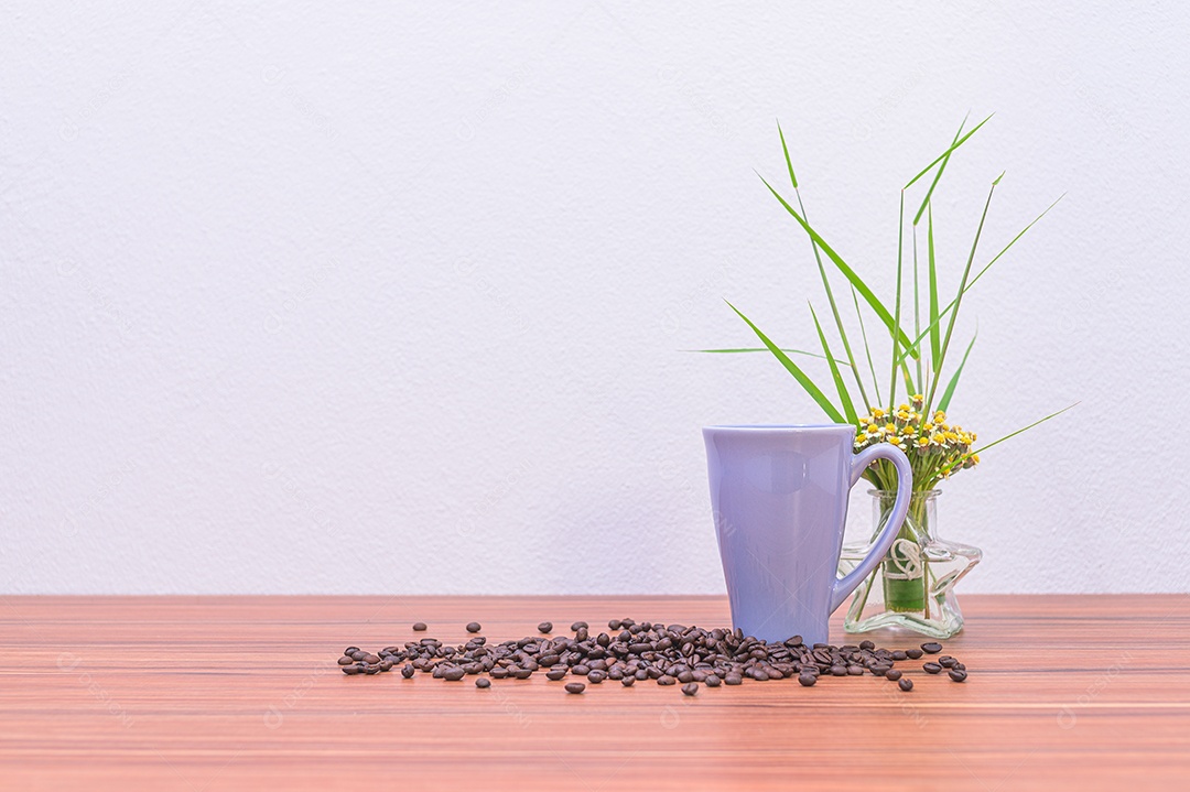 Grãos de café e vasos de flores na mesa