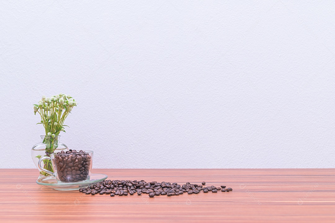 Grãos de café e vasos de flores na mesa