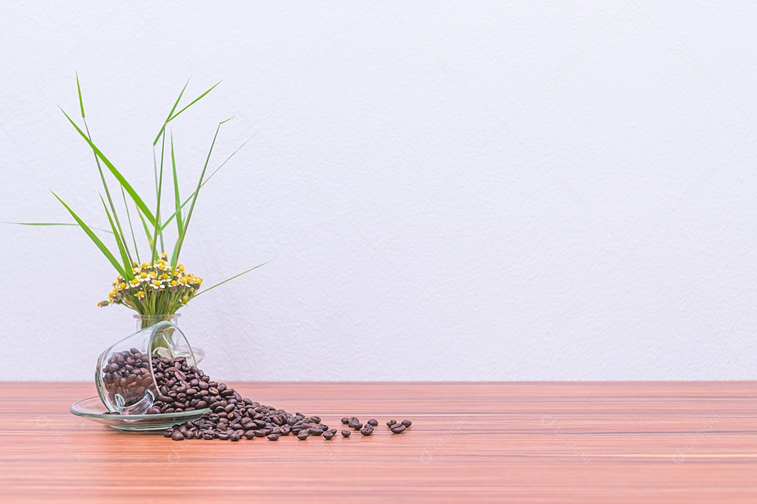 Grãos de café e vasos de flores na mesa
