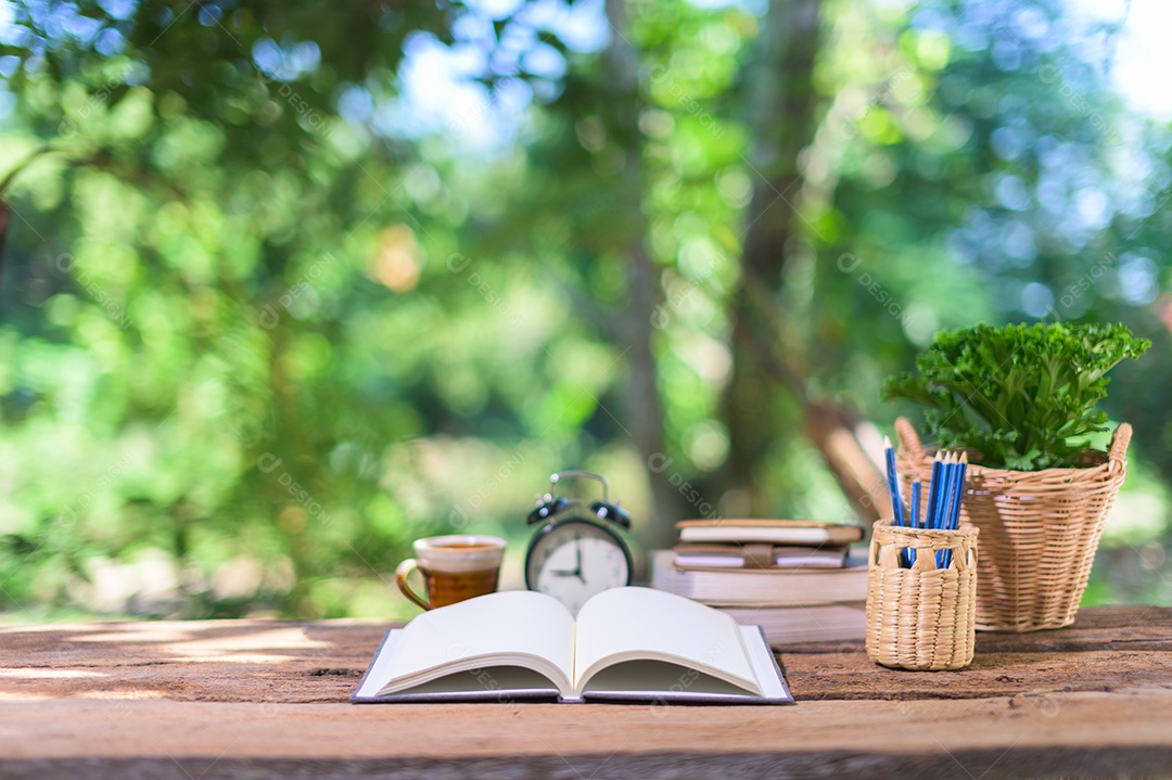 Livros, materiais de papelaria estão na mesa.