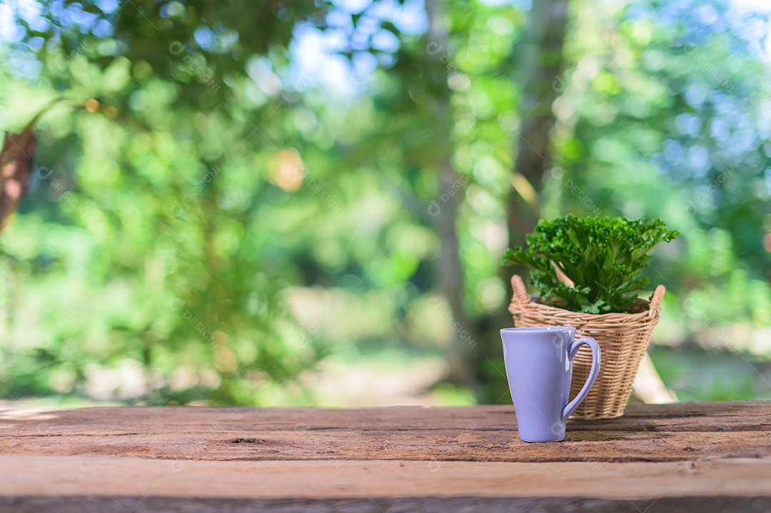 Caneca e vaso de planta estão na mesa.
